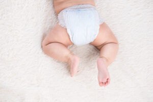baby in a diaper on floor  